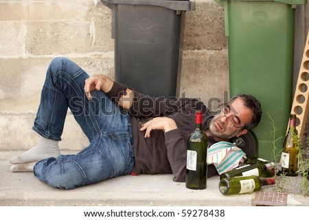 stock-photo-poor-and-drunk-man-lying-on-sidewalk-with-bottles-of-wine-near-trash-can-59278438.jpg